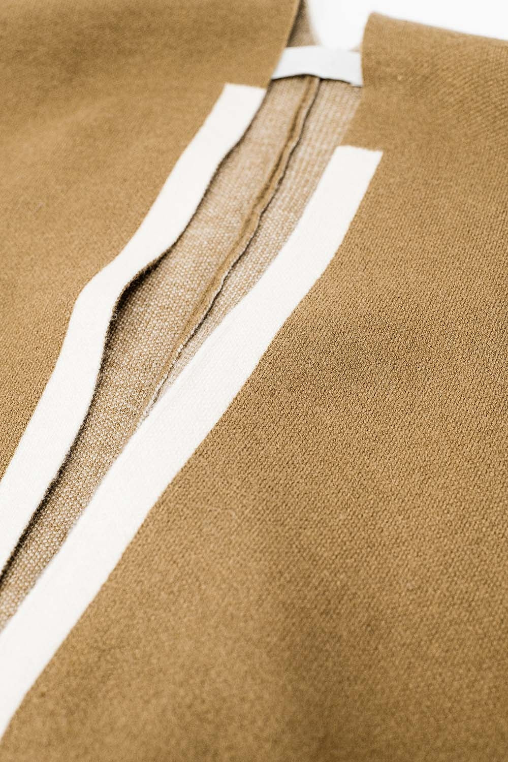Poncho de malha em camel com acabamento em cru