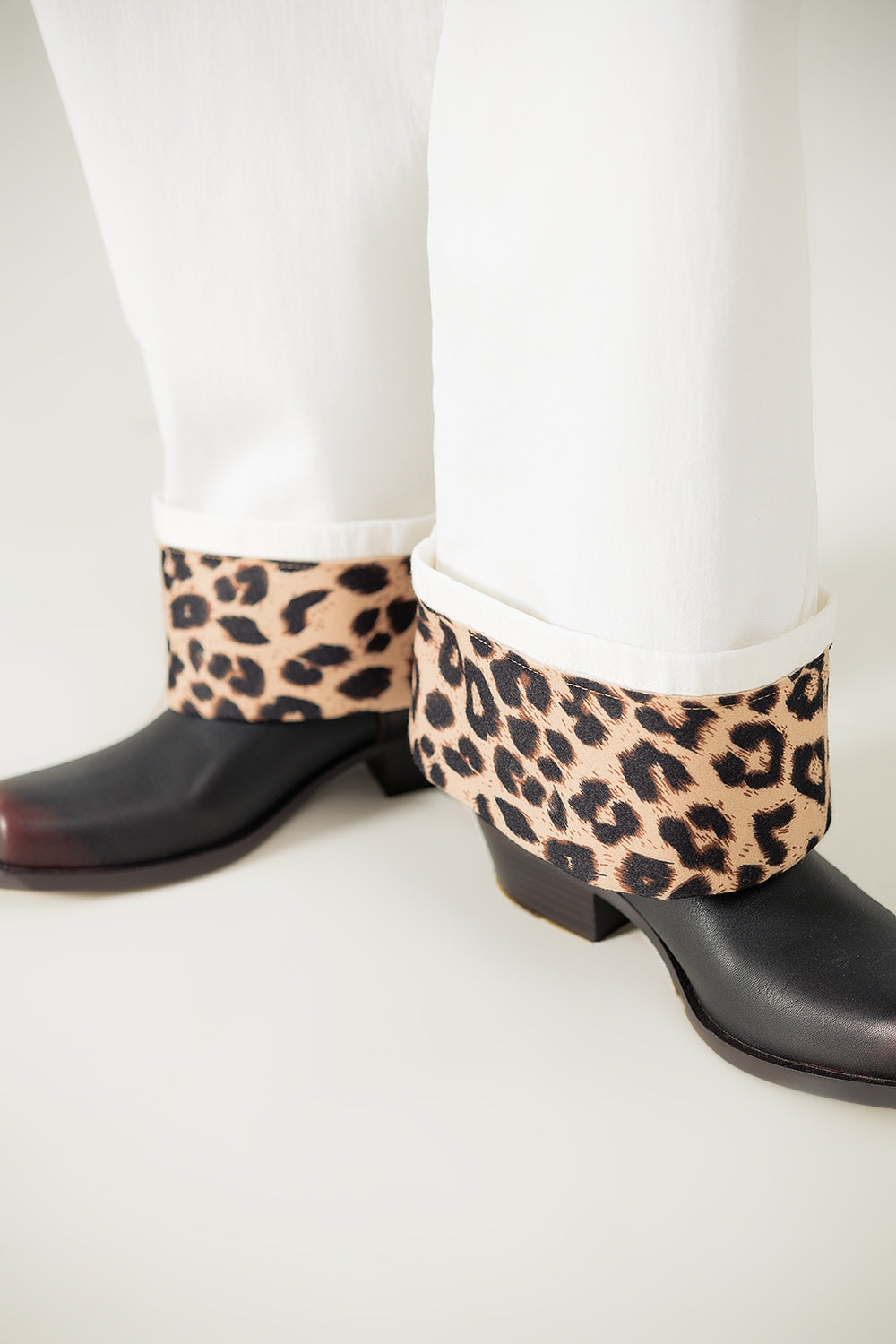 Calças largas em creme com estampado de leopardo na parte inferior
