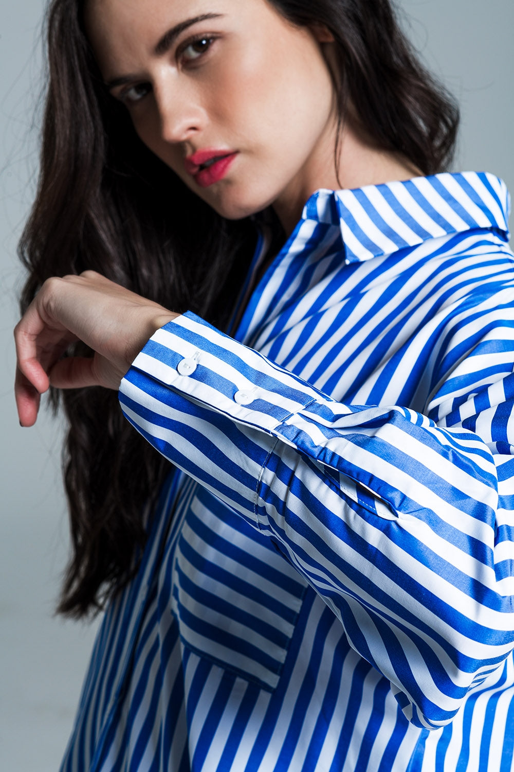 Blusa branca oversized com riscas verticais em azul e bolso no peito