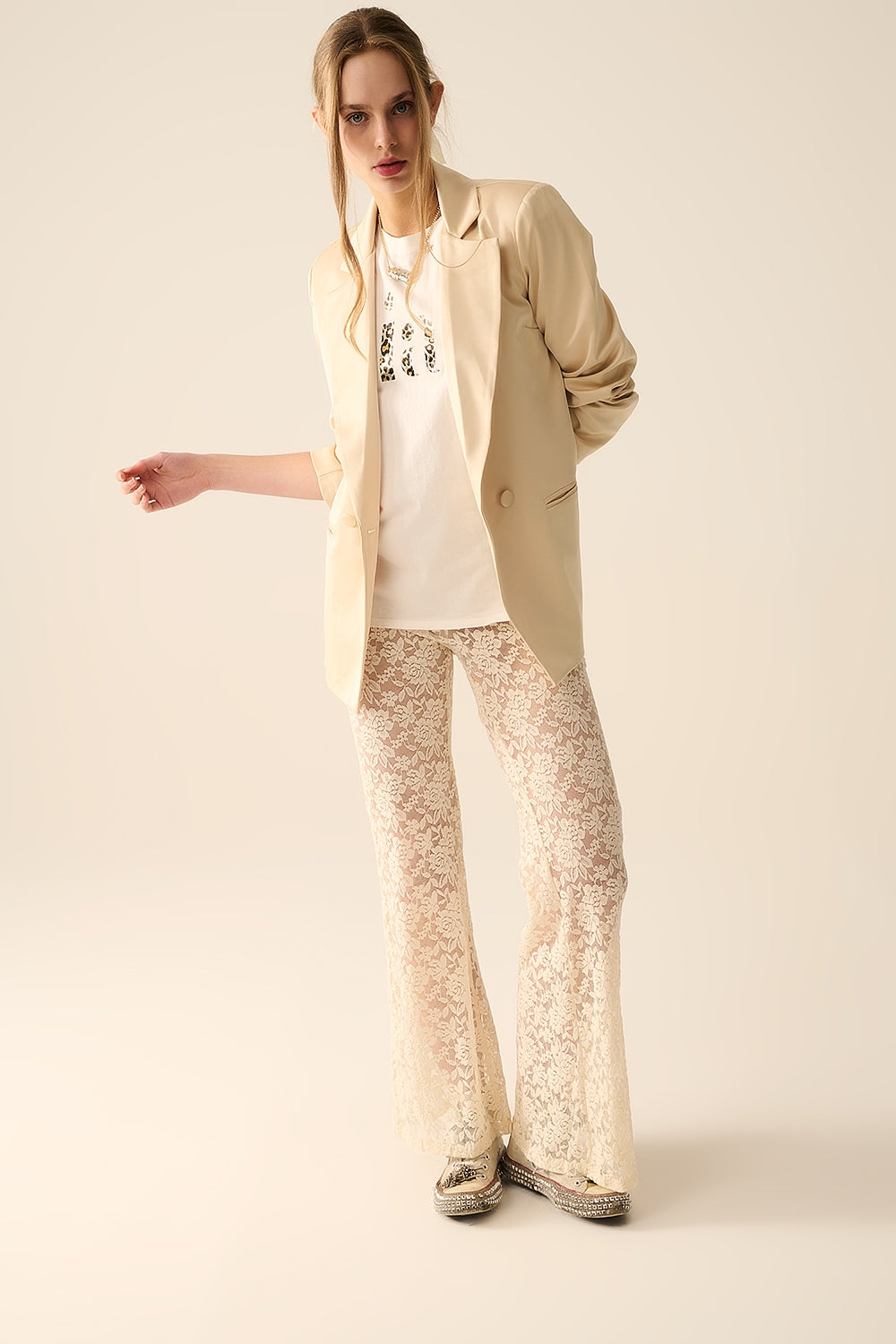 Calças flare de creme em renda floral