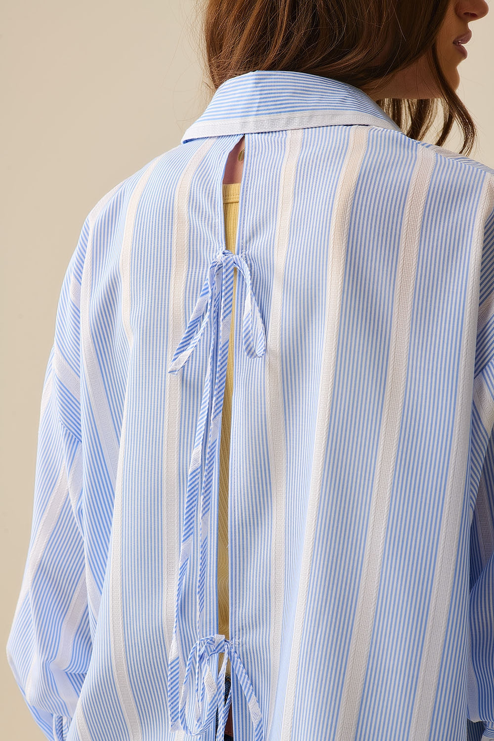 Camisa às riscas azul e branca de corte descontraído com laço nas costas