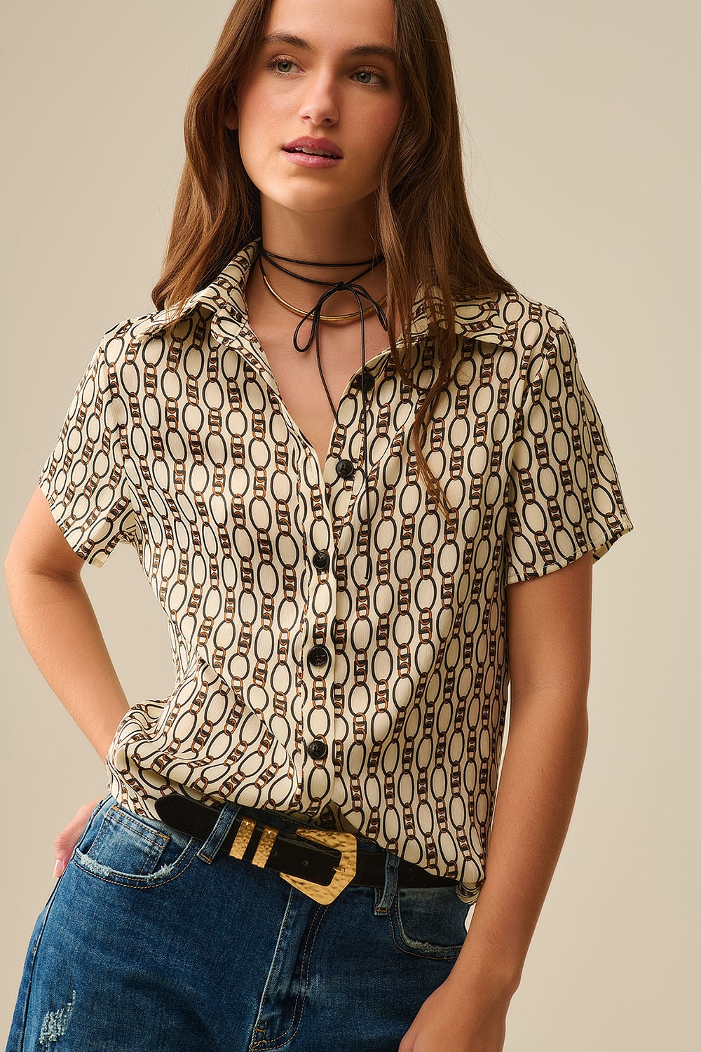 Camisa pólo bege de manga curta com estampado de correntes