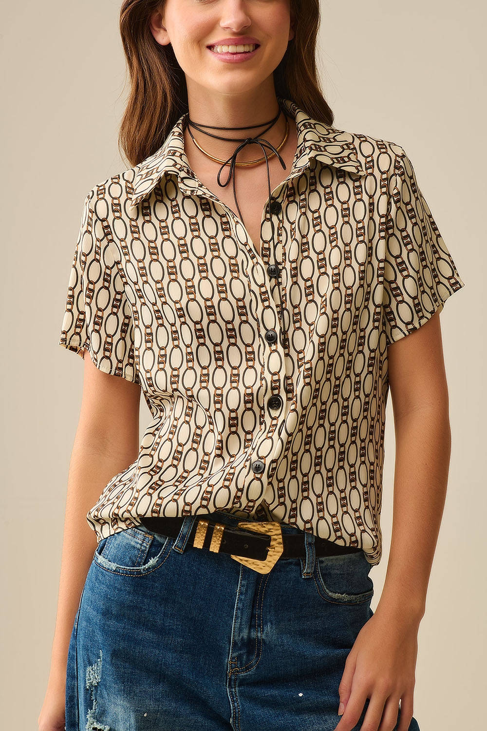 Camisa pólo bege de manga curta com estampado de correntes