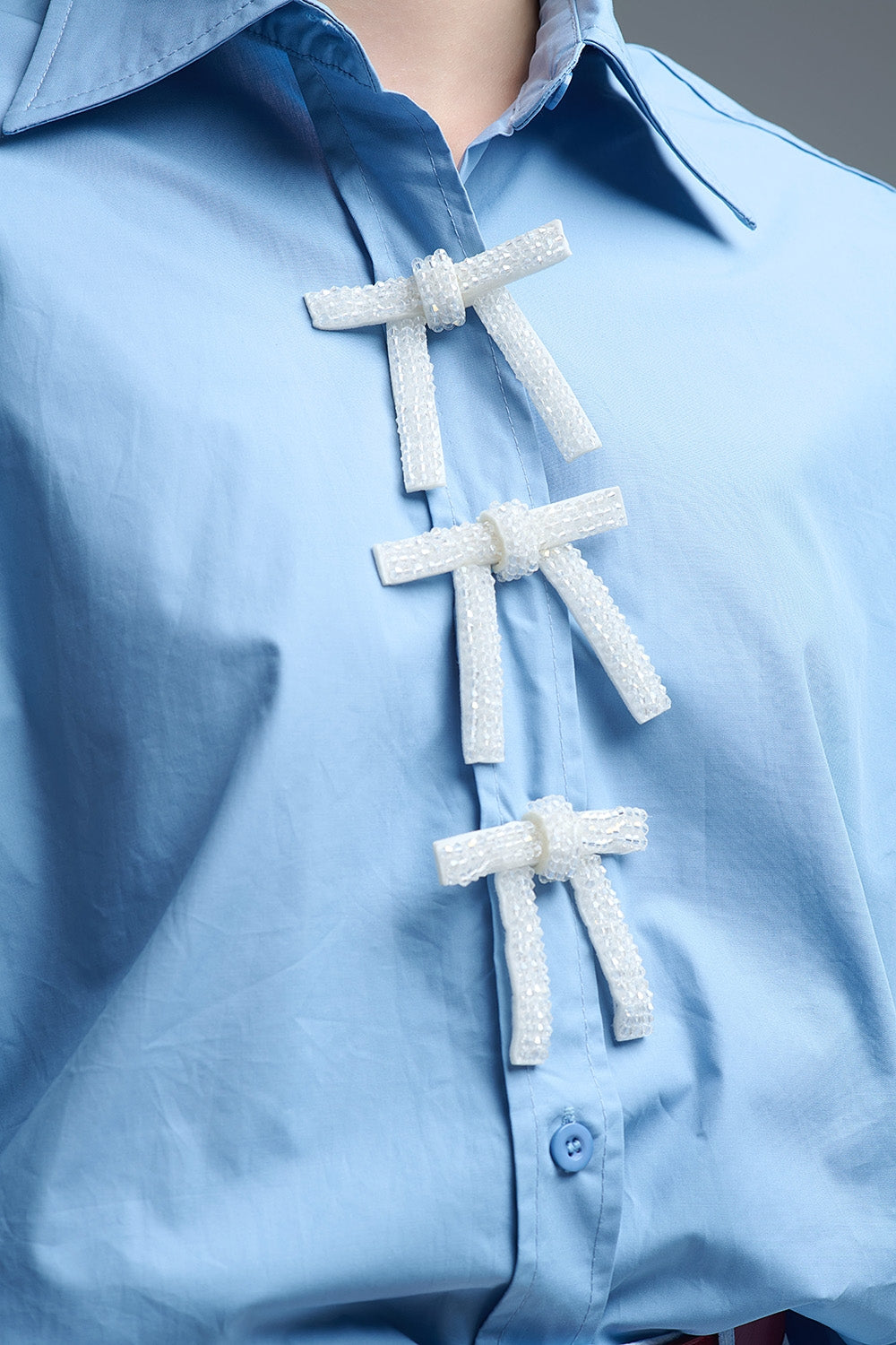 Camisa de popelina azul de tamanho grande com botões de laço brancos com brilhantes