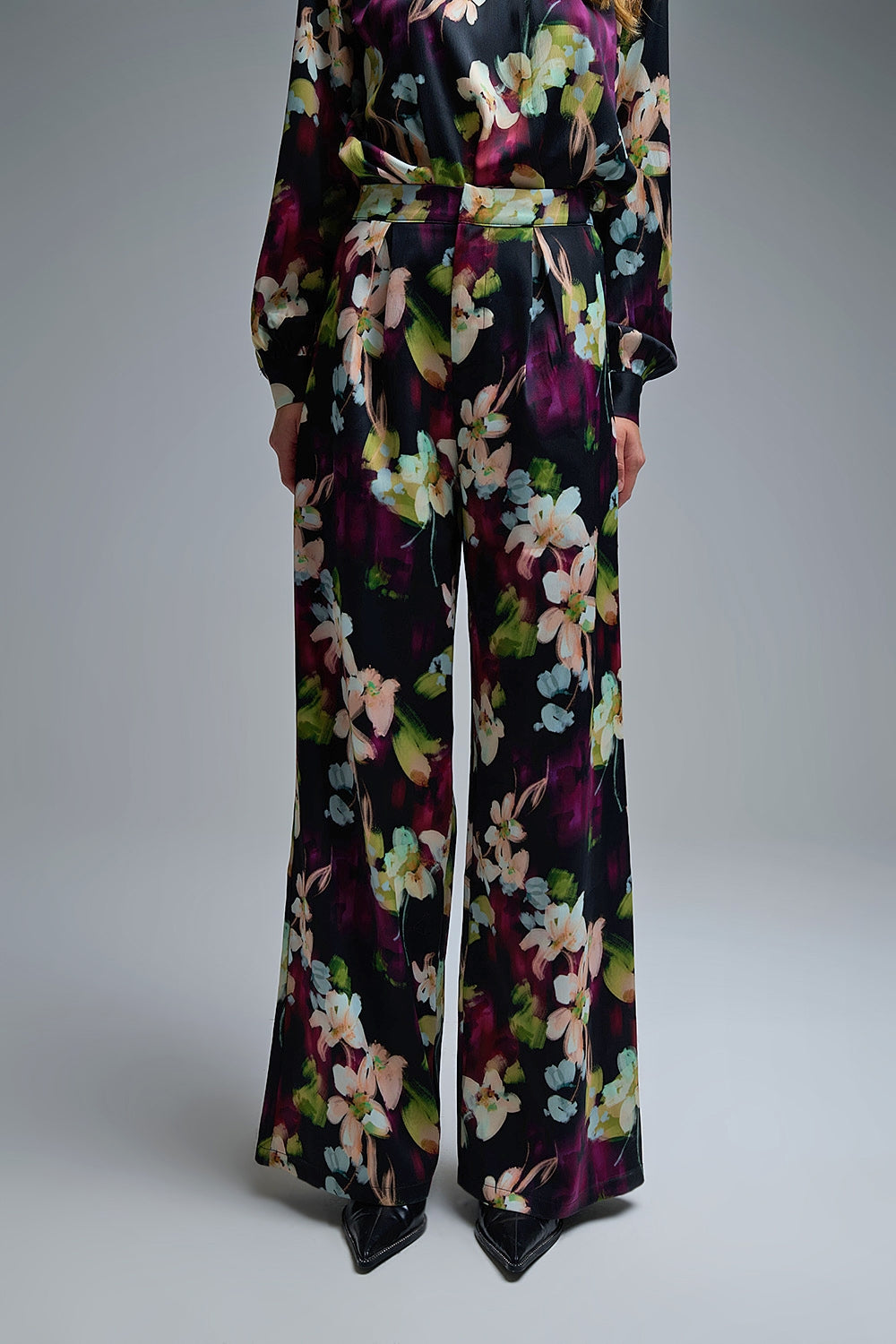 Calças fluidas com estampado floral em tecido acetinado com bolsos laterais