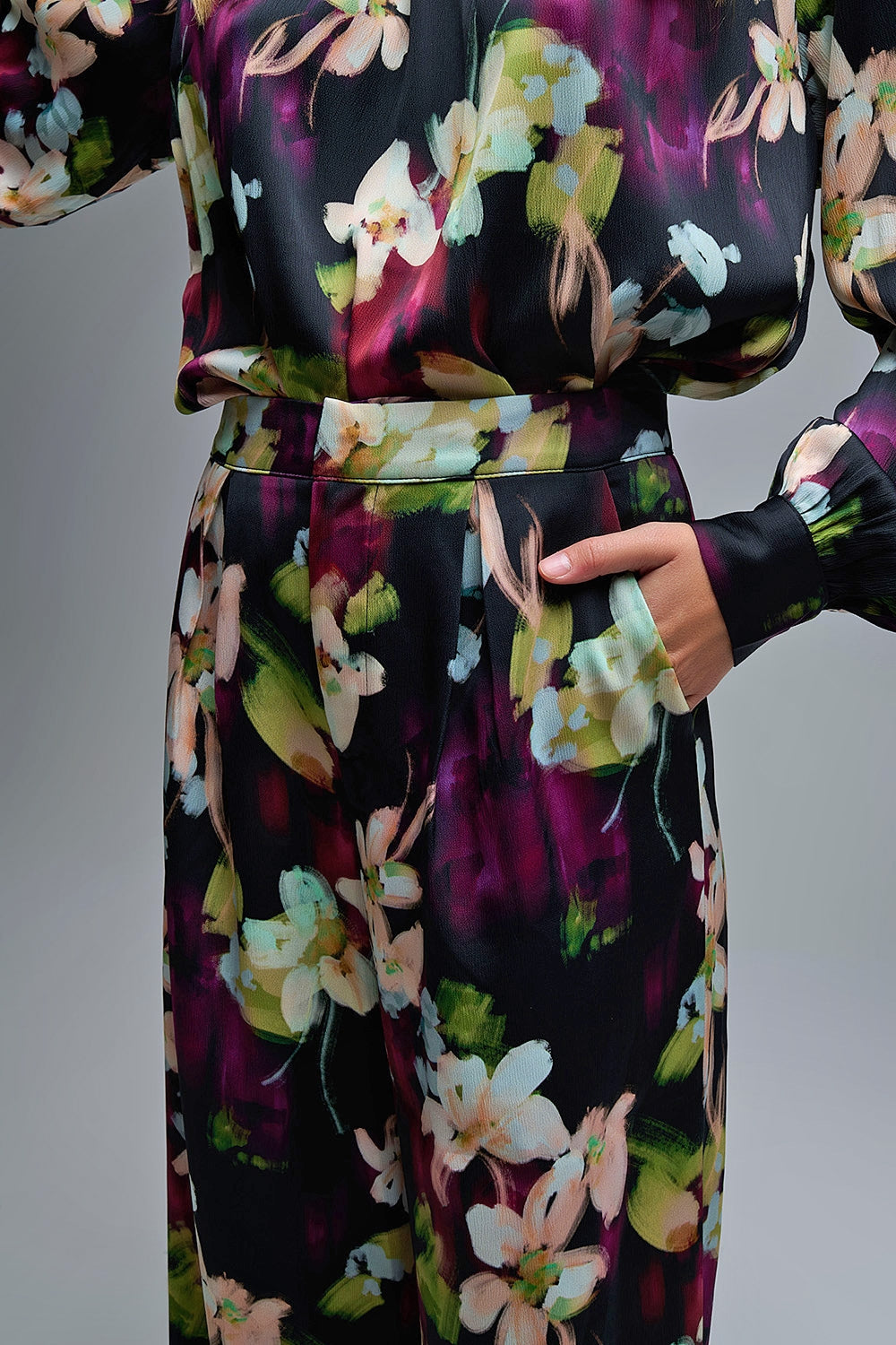 Calças fluidas com estampado floral em tecido acetinado com bolsos laterais