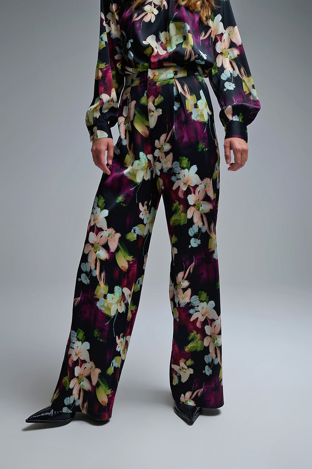 Calças fluidas com estampado floral em tecido acetinado com bolsos laterais