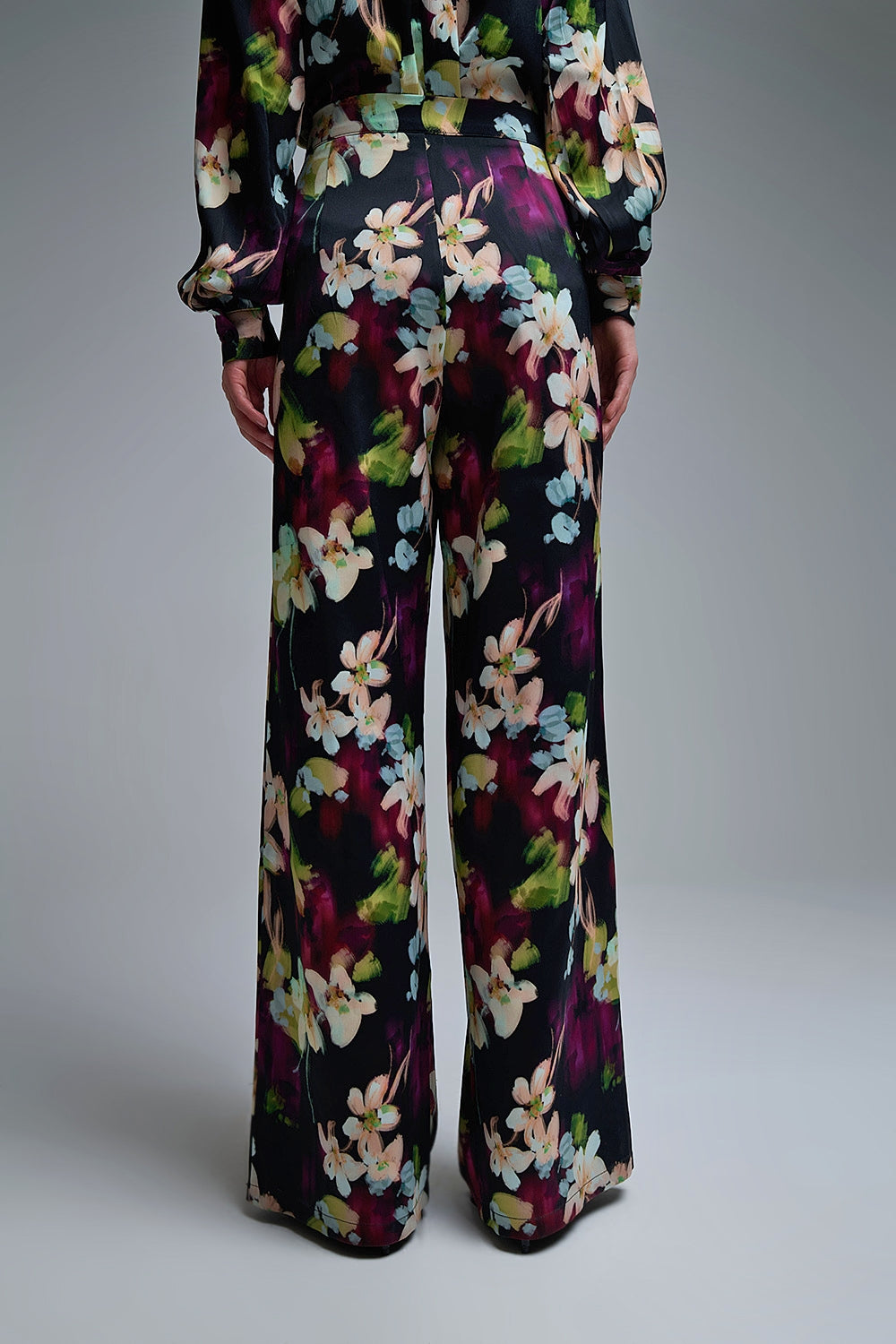 Calças fluidas com estampado floral em tecido acetinado com bolsos laterais