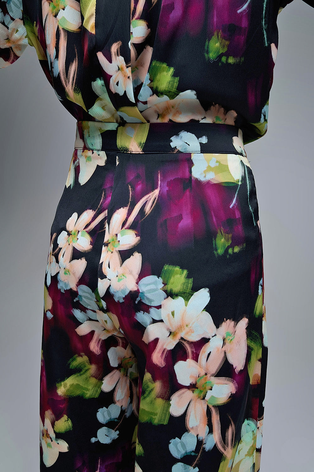 Calças fluidas com estampado floral em tecido acetinado com bolsos laterais