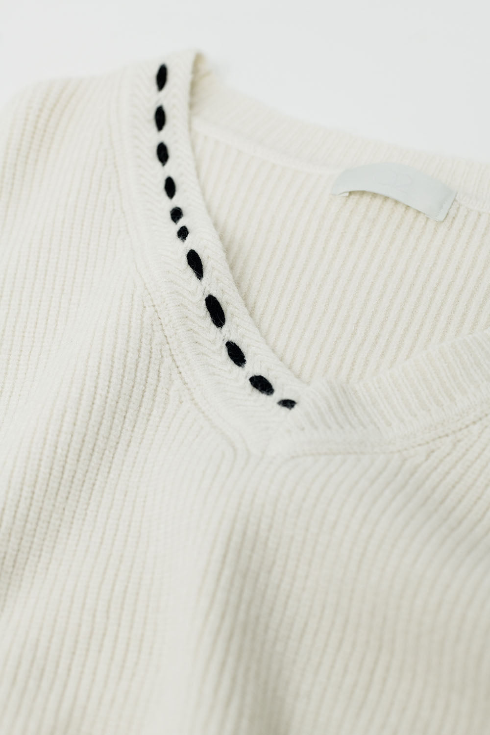 Camisola com gola em V e pormenor bordado em preto