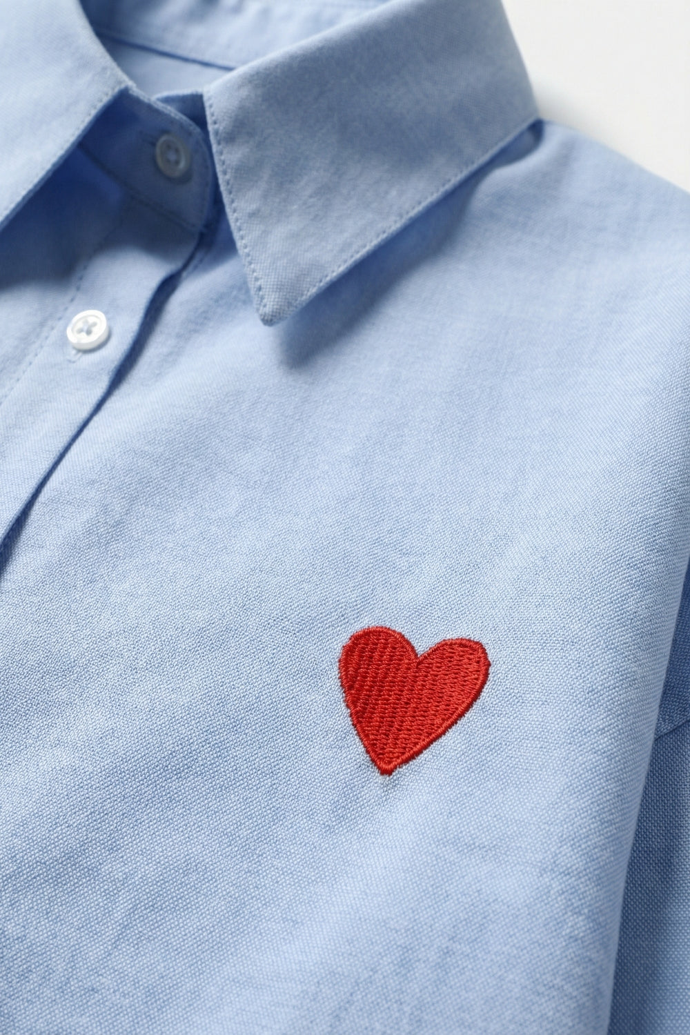 Camisa azul de algodão Oxford com pormenor de coração vermelho bordado