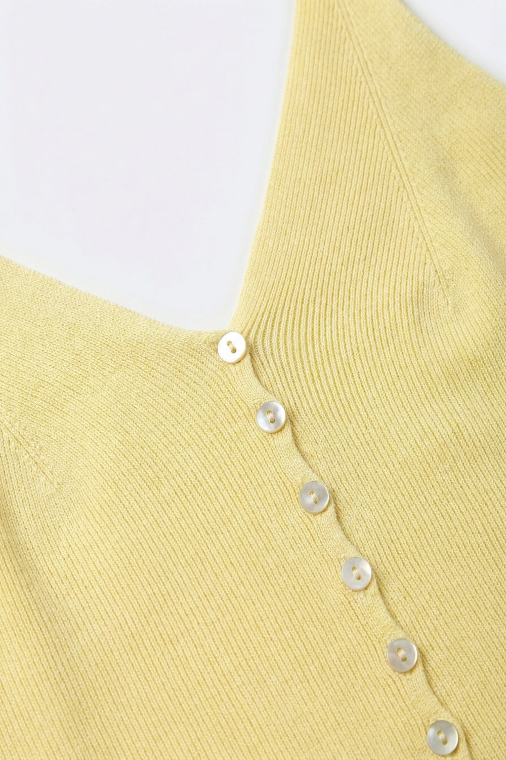 Top de malha com botões em amarelo