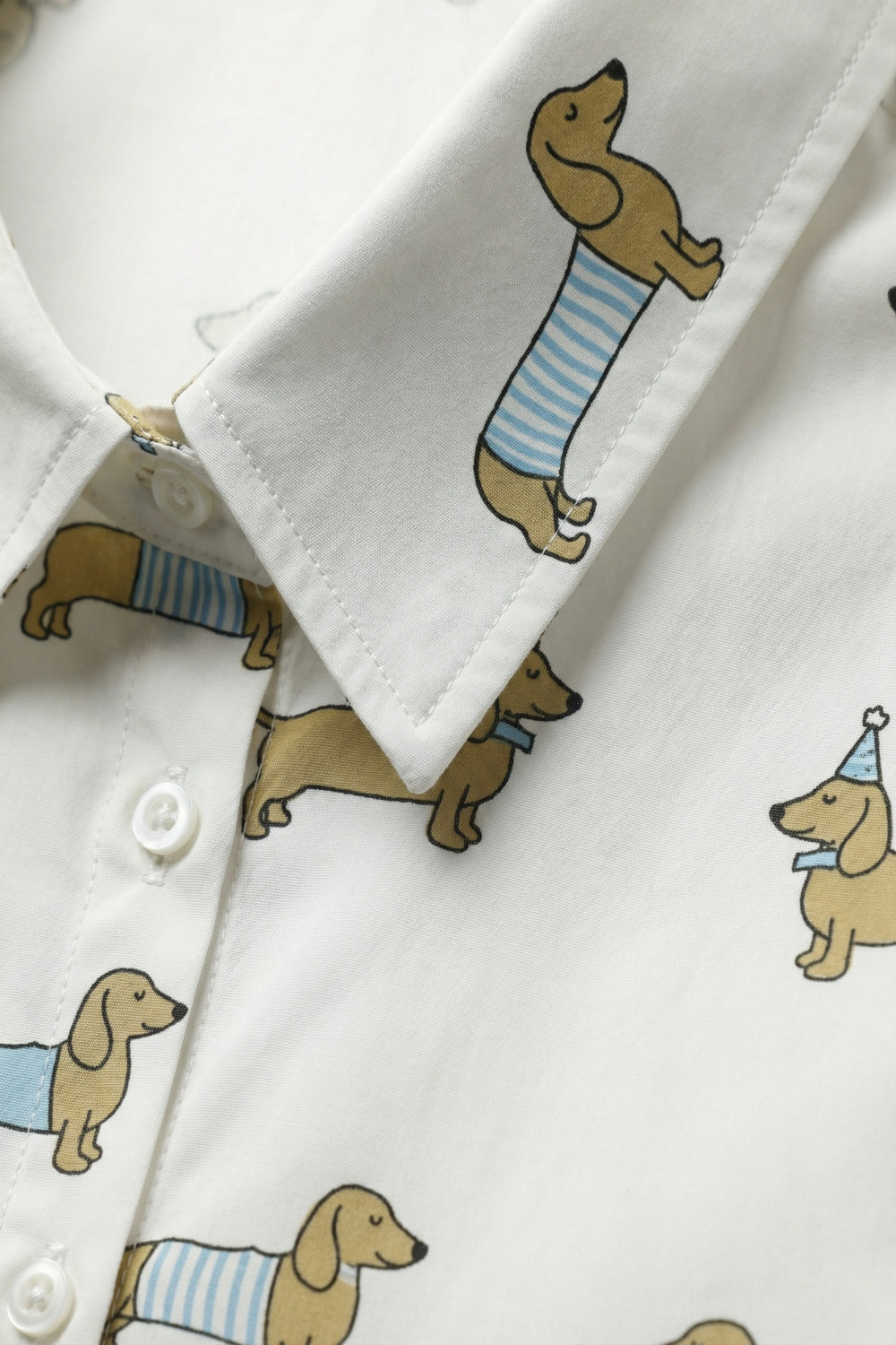 Camisa branca com botões e estampado de um cão brincalhão