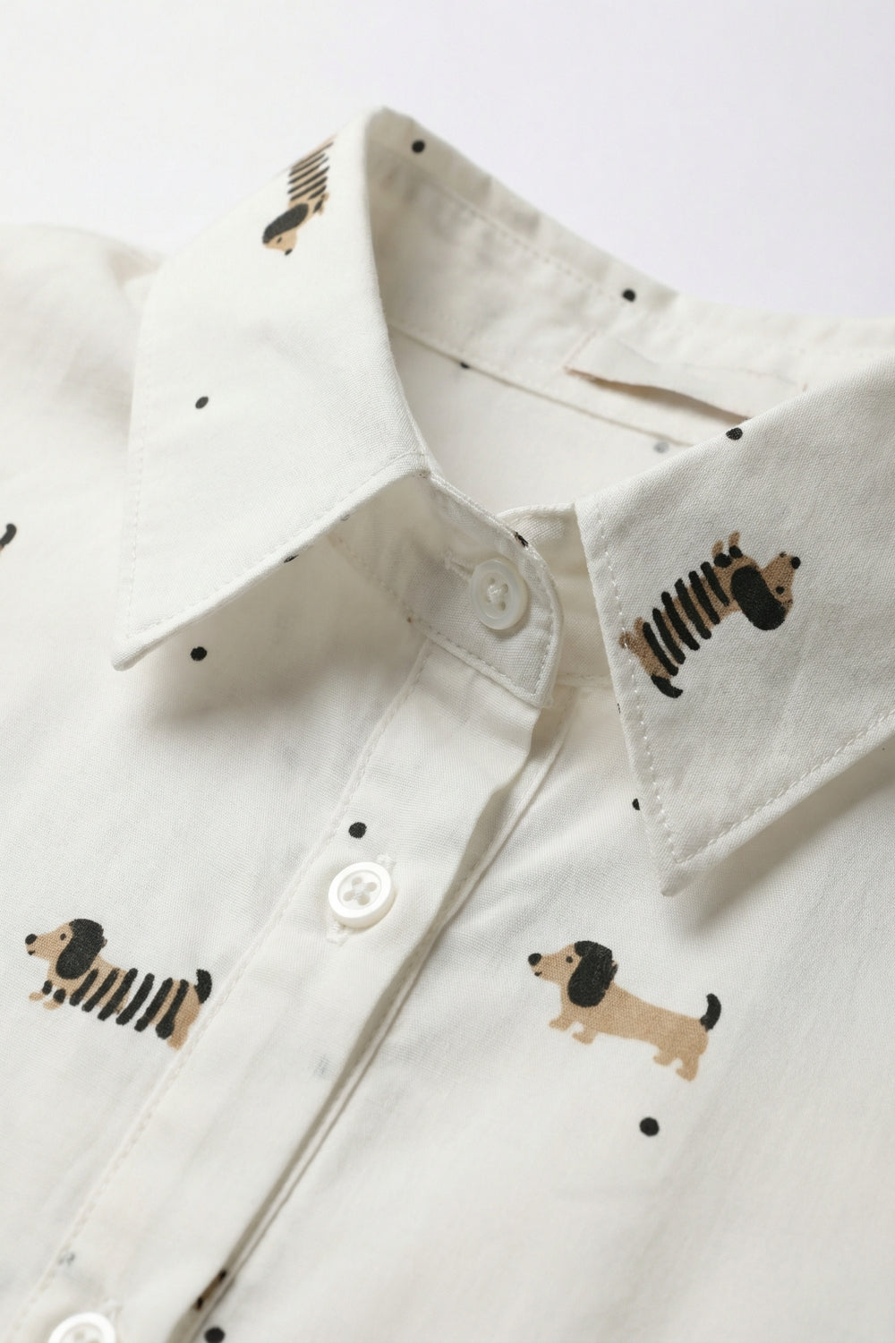 Camisa branca com botões e estampado de um cão brincalhão