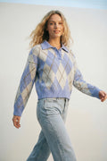 Camisola de malha azul com padrão de losangos e gola polo.
