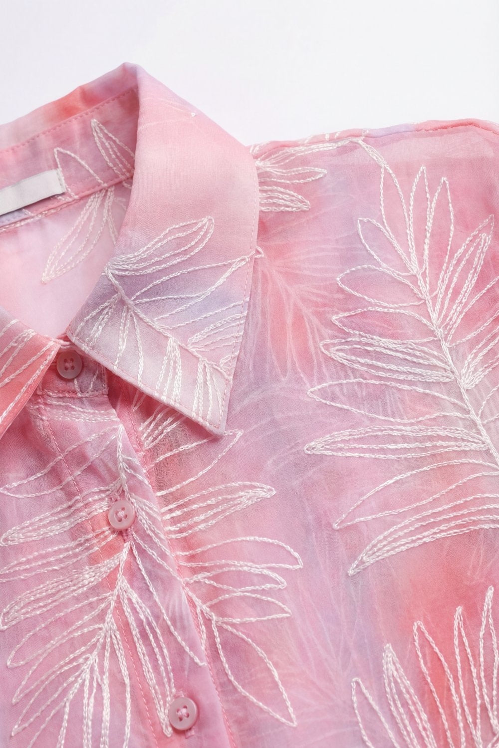 Camisa rosa com estampa de folhas translúcidas e tecido transparente