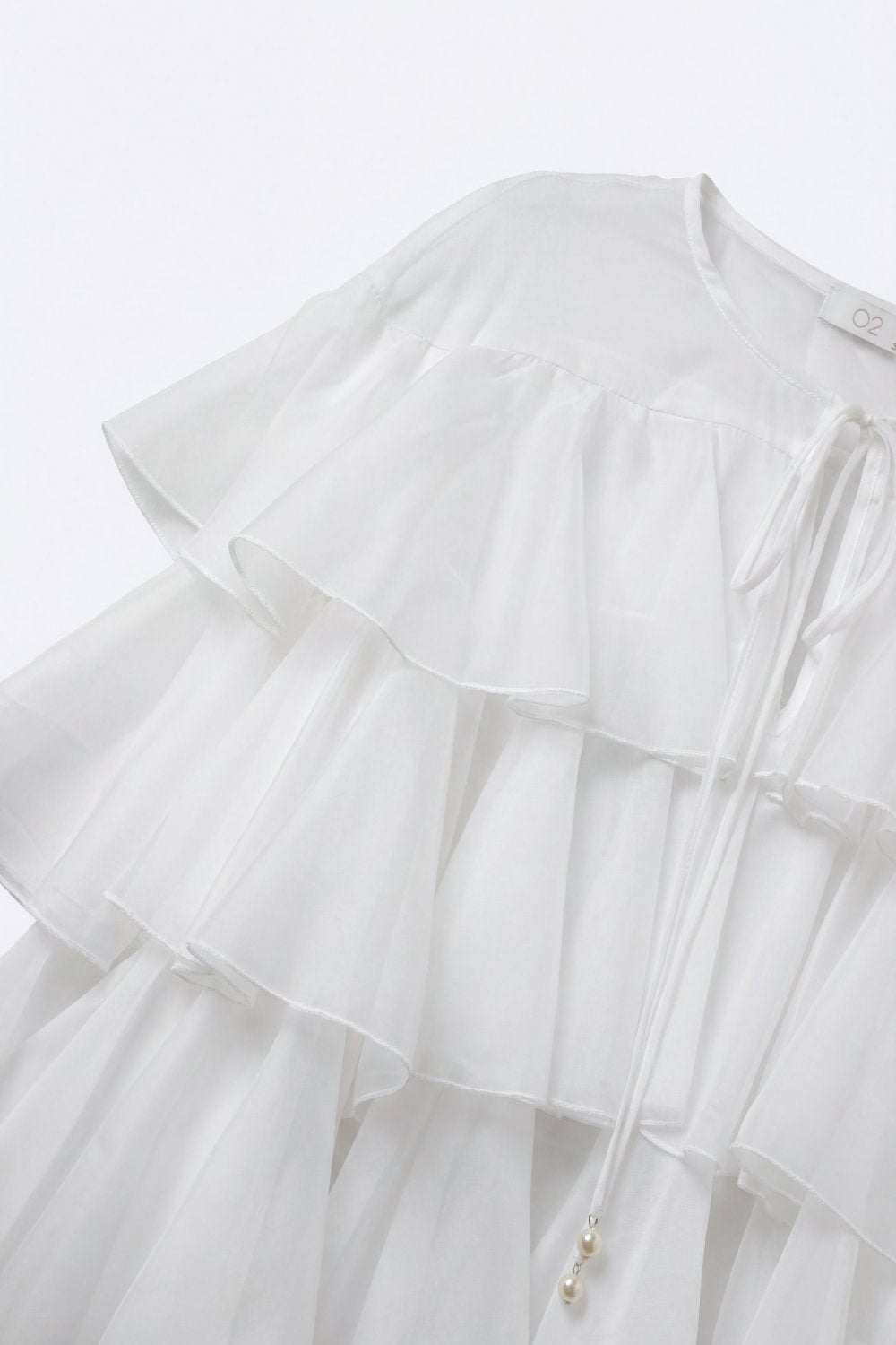 Blusa Branca com Babados em Camadas e Laço no Pescoço