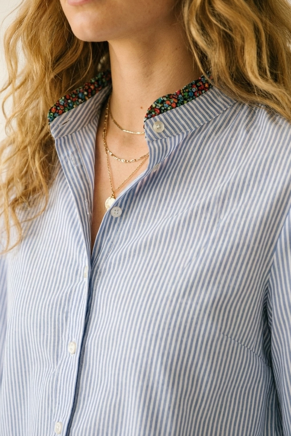 Camisa com botões às riscas azul-clara com adorno floral