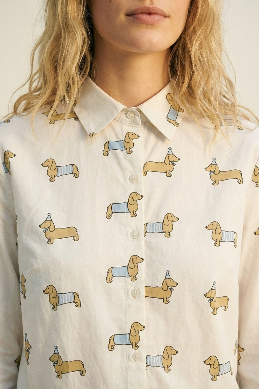 Camisa branca com botões e estampado de um cão brincalhão