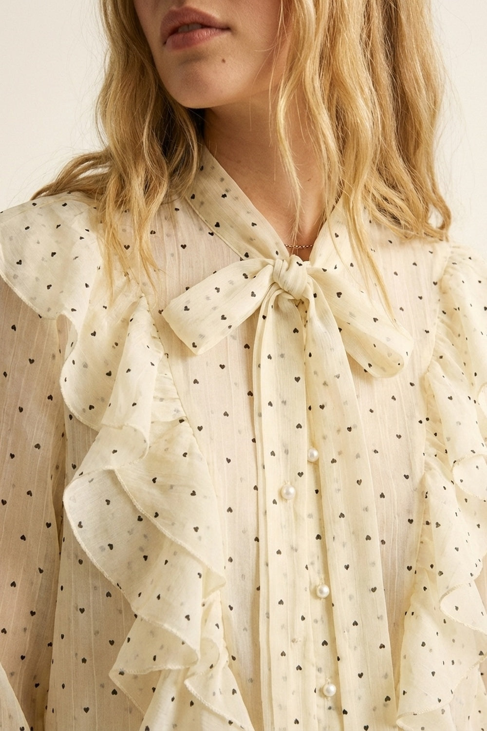 Blusa de bolinhas com folho à frente e punhos com folhos