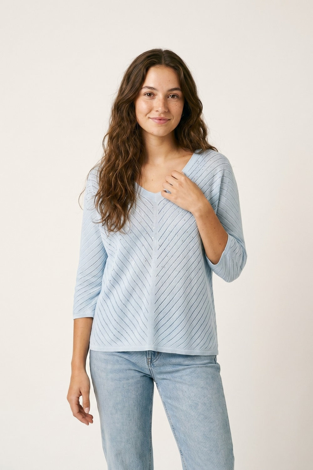 Camisola de malha azul clara com decote em V e pormenores brilhantes
