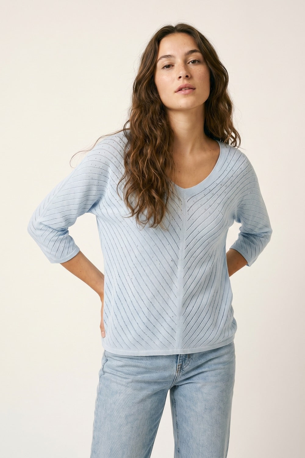 Camisola de malha azul clara com decote em V e pormenores brilhantes