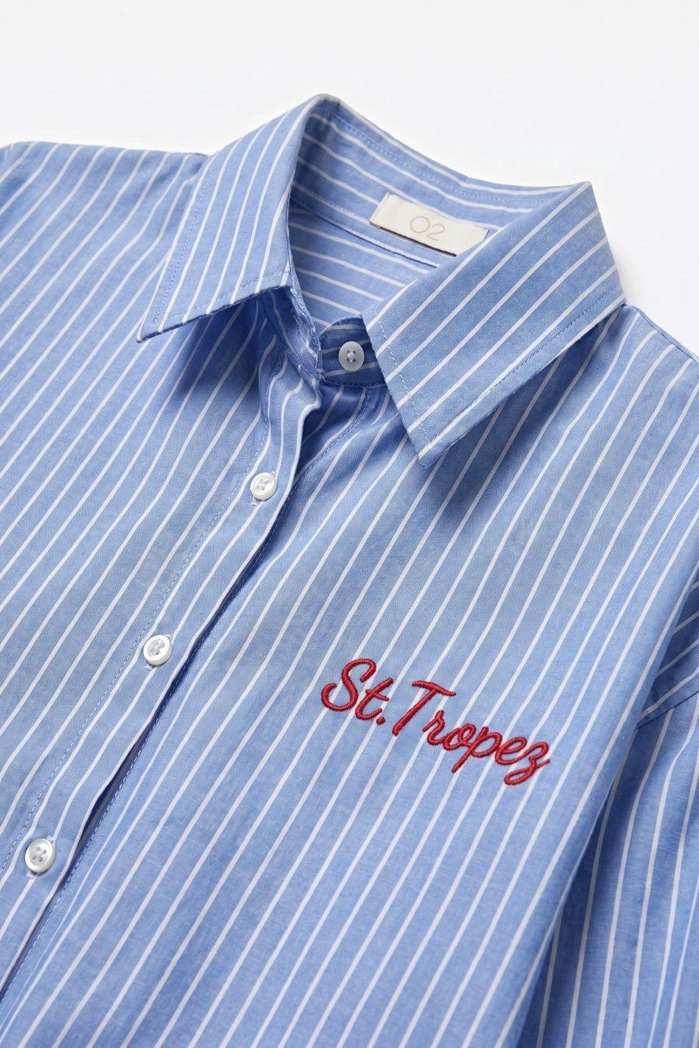 Camisa clássica de riscas azuis com botões e bordados
