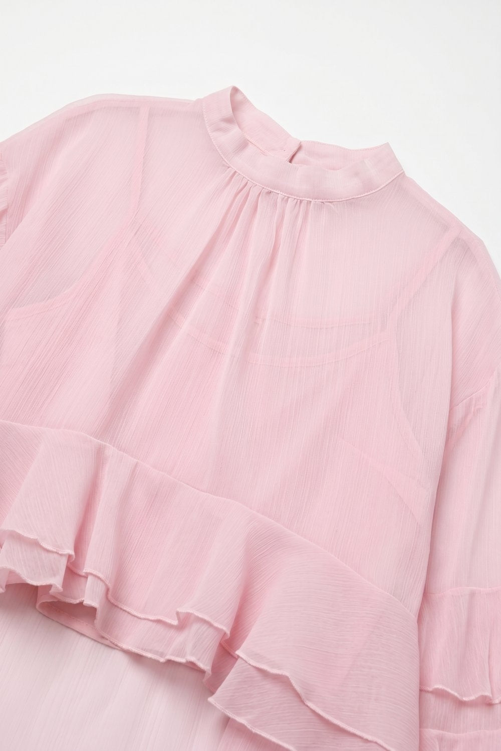 Blusa assimétrica de chiffon rosa claro com folhos em camadas e gola alta.