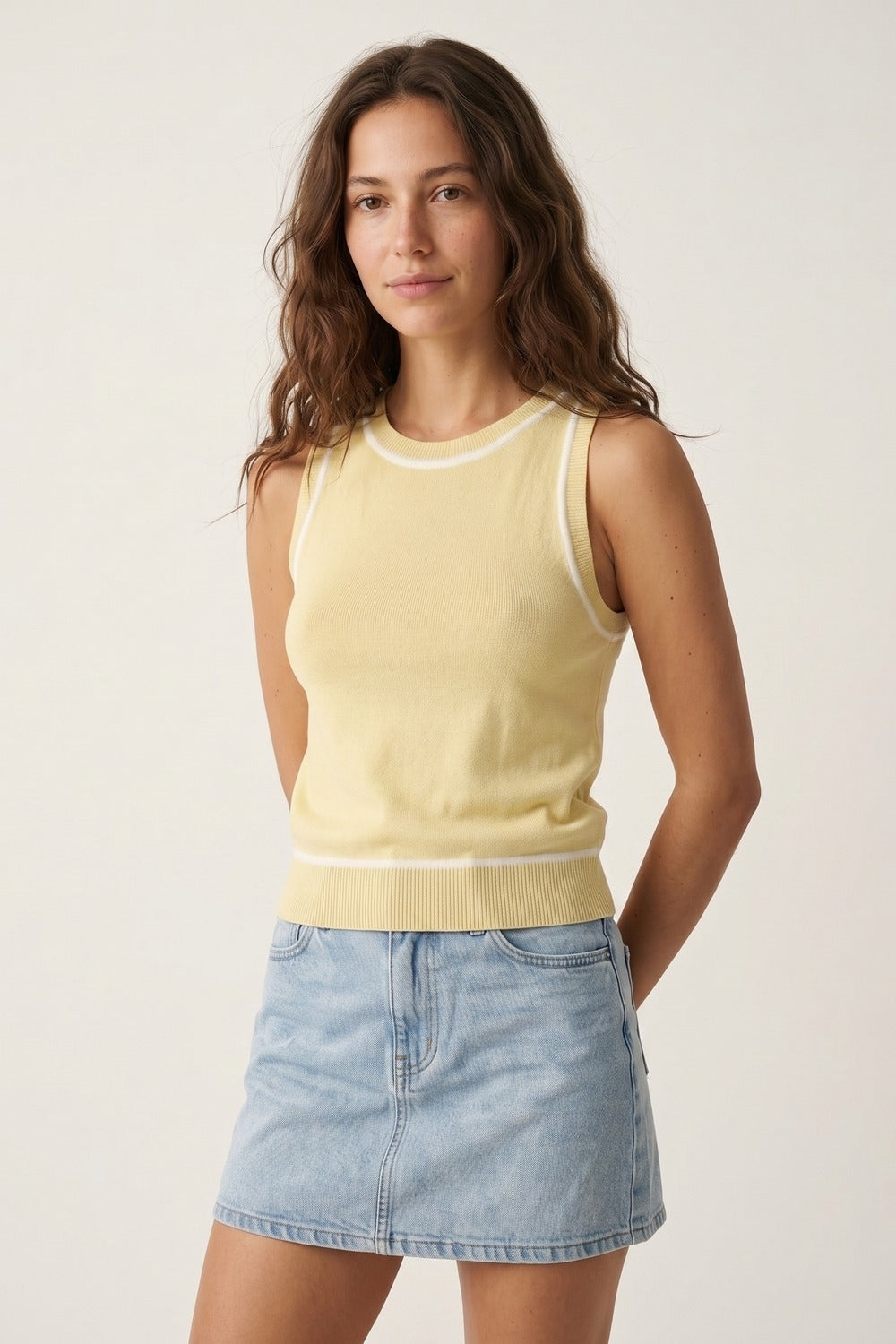Top de malha sem mangas em amarelo manteiga com detalhes de linhas brancas