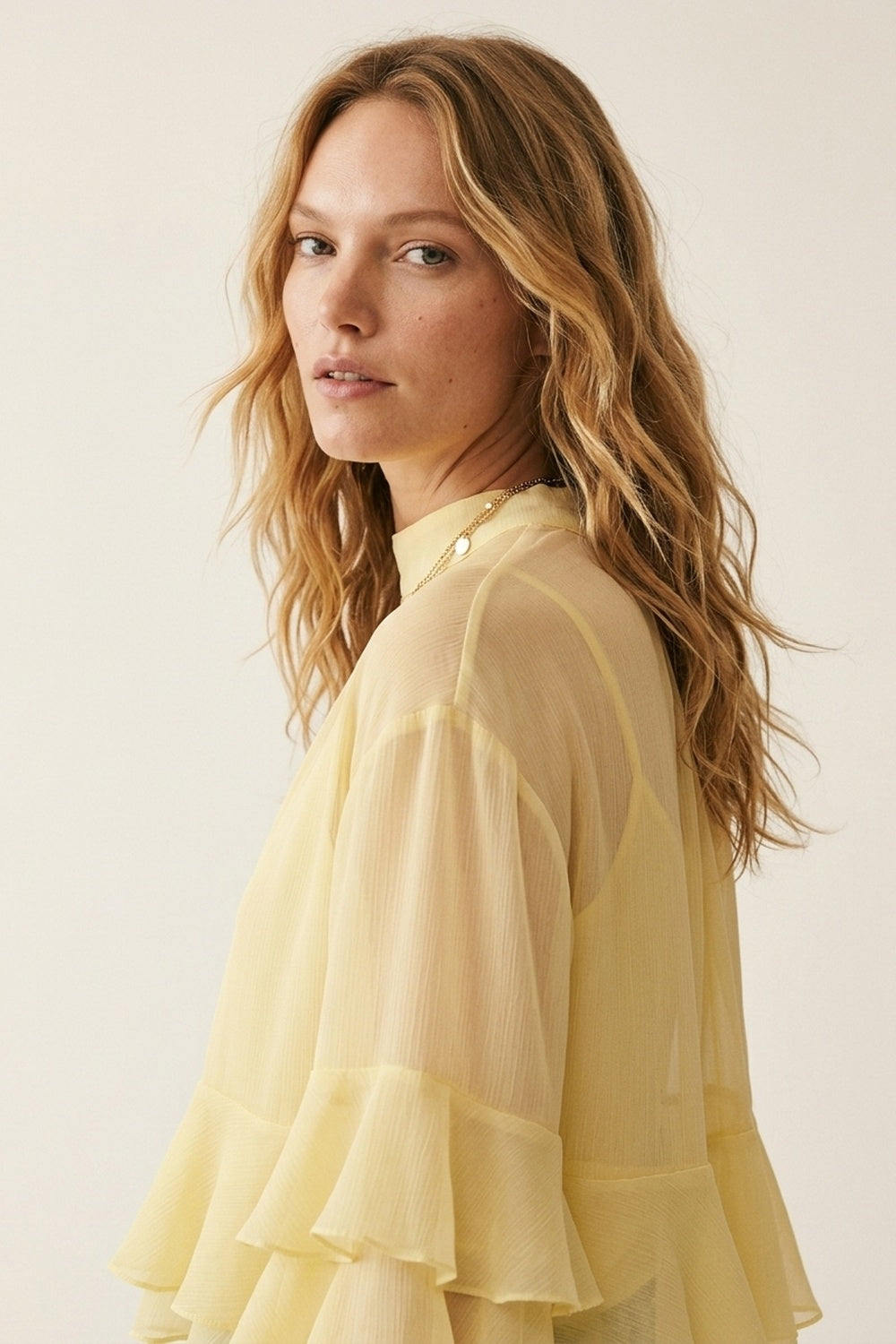 Blusa amarela em chiffon com folhos, mangas flare e gola alta