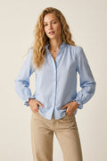 Camisa azul-clara com botões e gola canelada