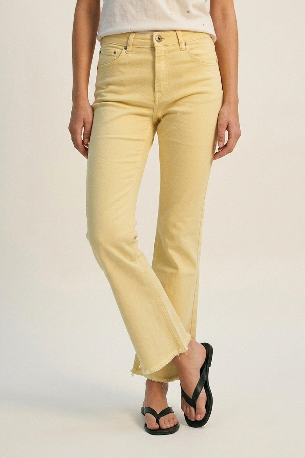 Calças jeans flare com barra desfiada na cor amarela