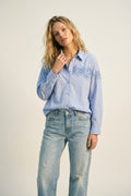 Camisa com botões azul clara com pormenor de renda