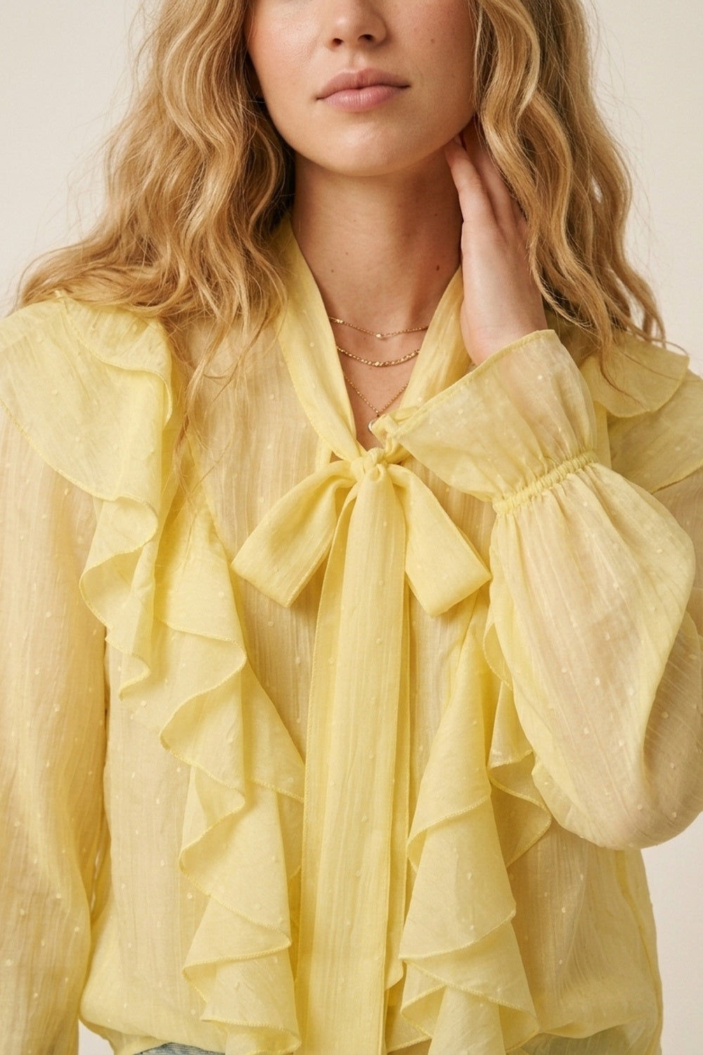 Blusa amarela com folhos e laço no pescoço