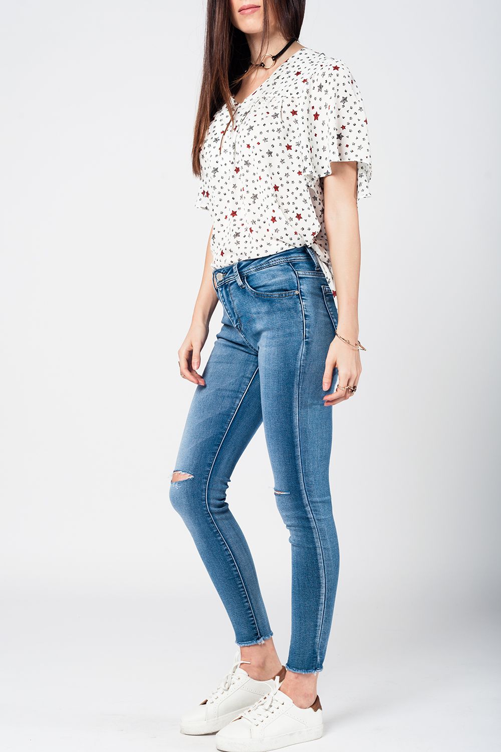 Jeans apertados com baixa joelho lavagem média desgastado e quebrado