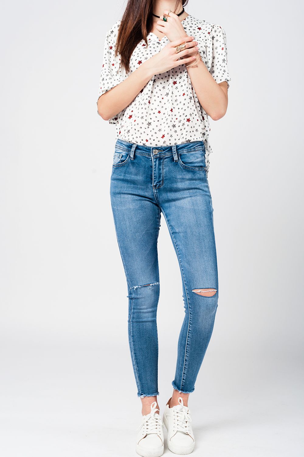 Jeans apertados com baixa joelho lavagem média desgastado e quebrado