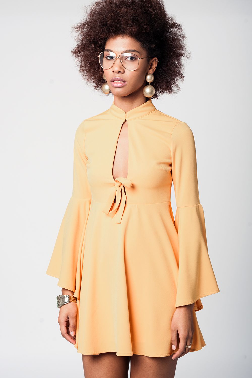 Vestido amarelo com mangas sino e decote profundo