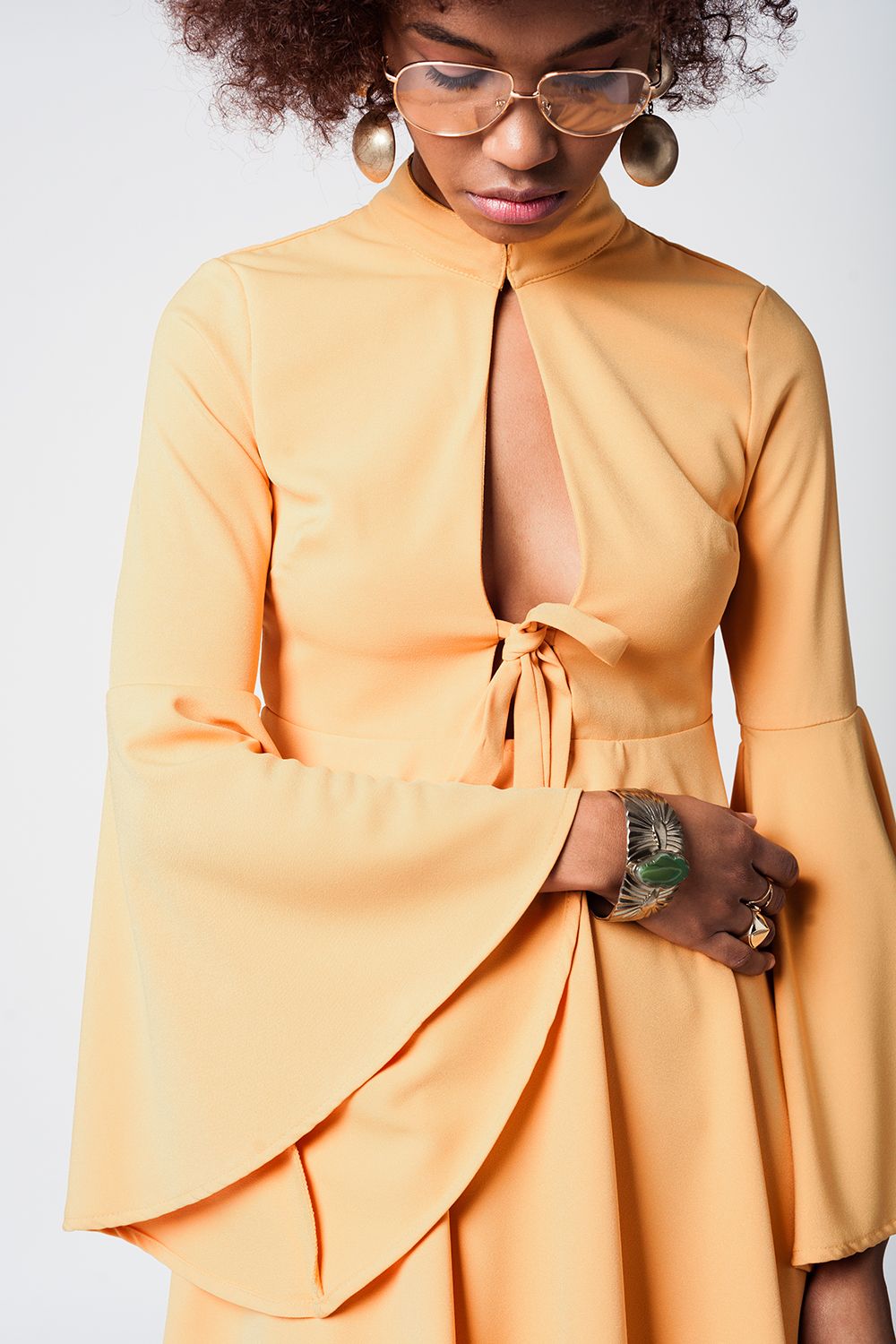 Vestido amarelo com mangas sino e decote profundo
