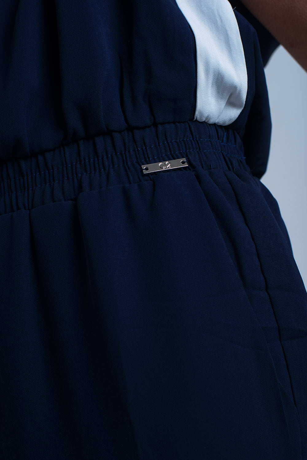 Macacão azul marinho com mangas curtas e detalhes de babados