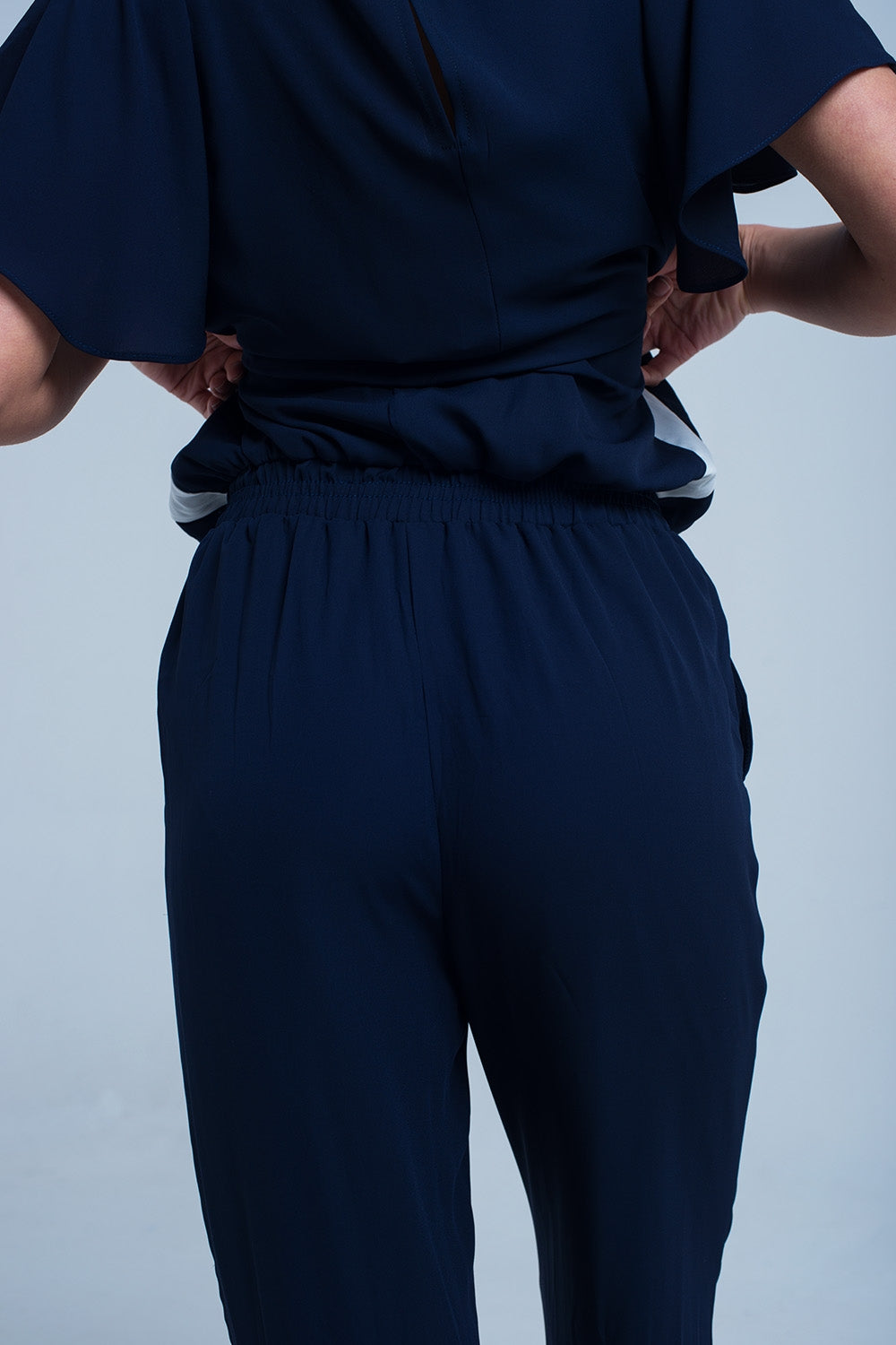 Macacão azul marinho com mangas curtas e detalhes de babados