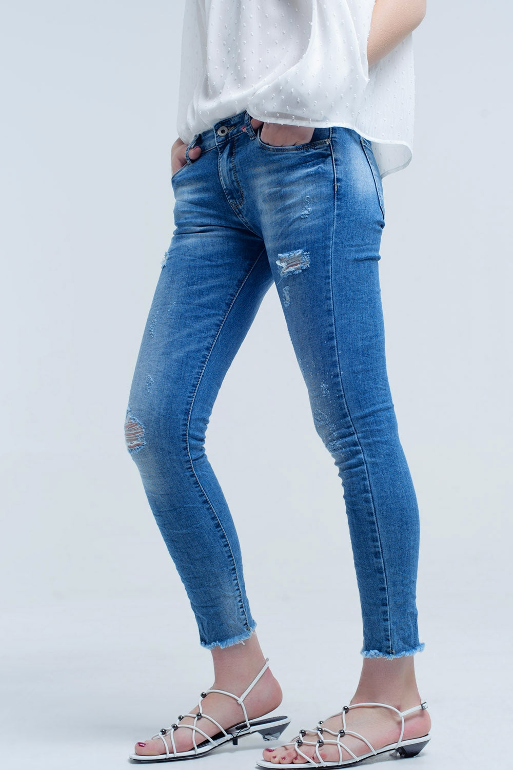 Calça jeans skinny em lavagem média com rasgos