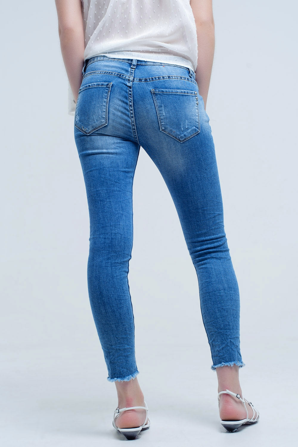 Calça jeans skinny em lavagem média com rasgos