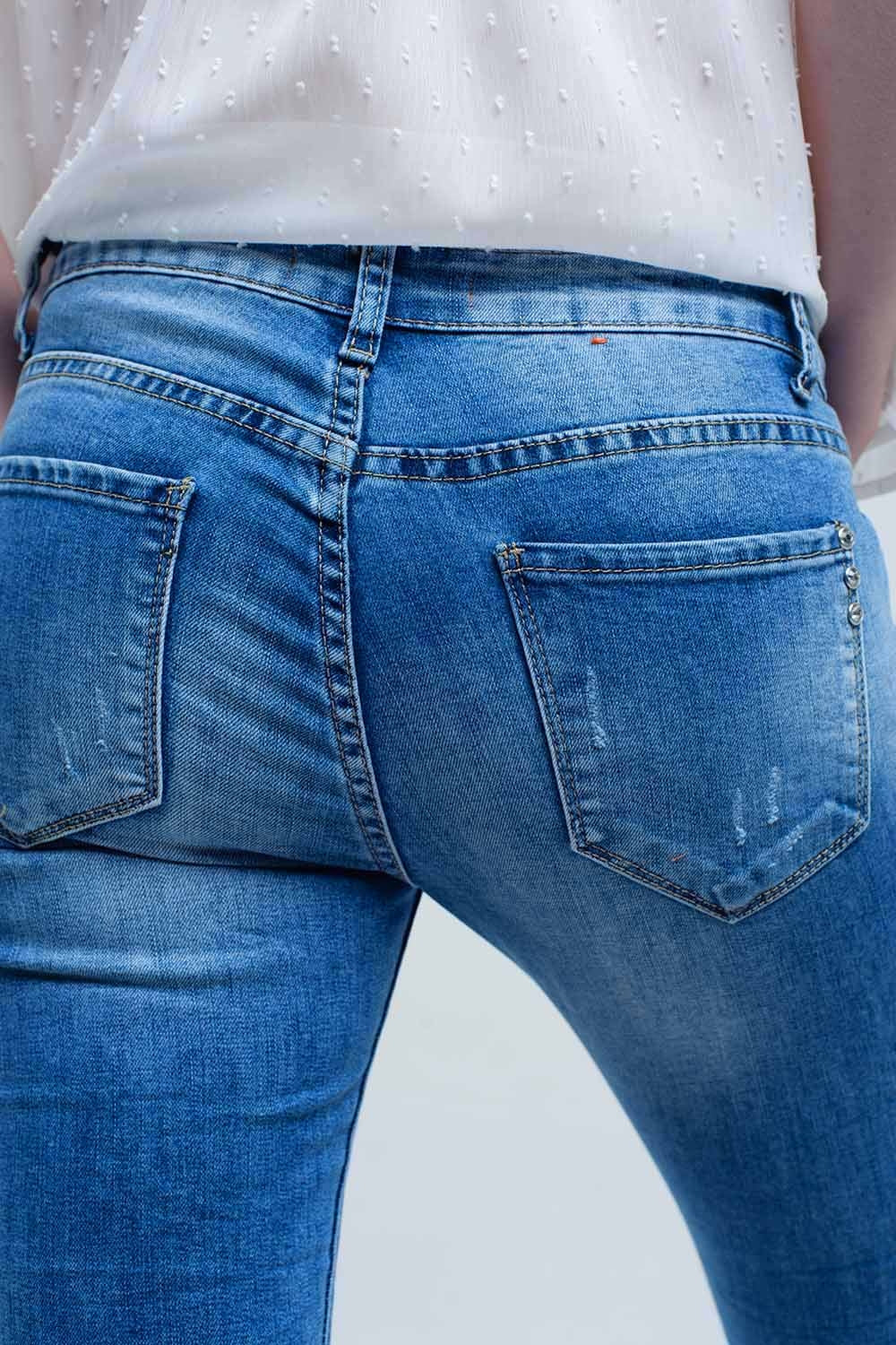 Calça jeans skinny em lavagem média com rasgos