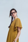 Vestido amarelo com voo e padrão geométrico