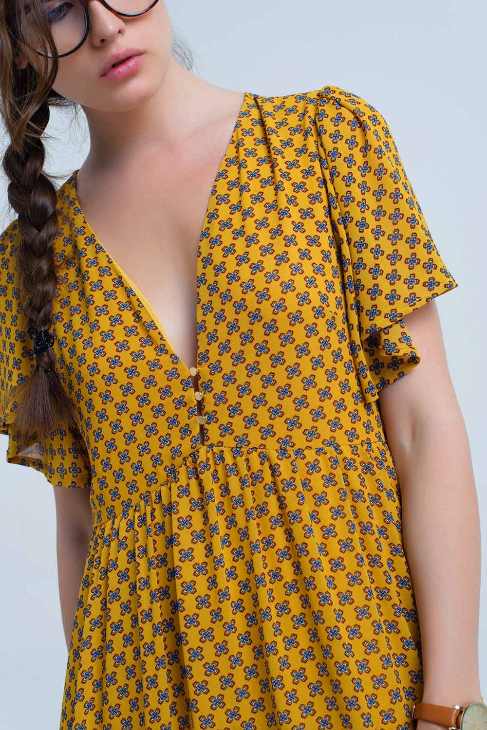 Vestido amarelo com voo e padrão geométrico