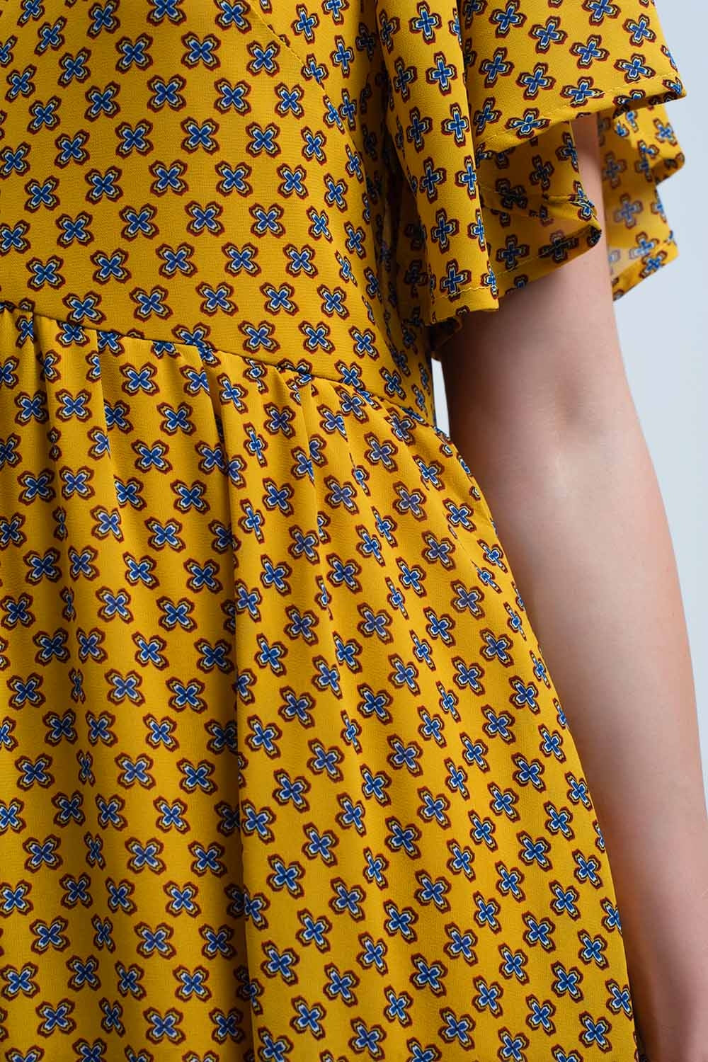 Vestido amarelo com voo e padrão geométrico