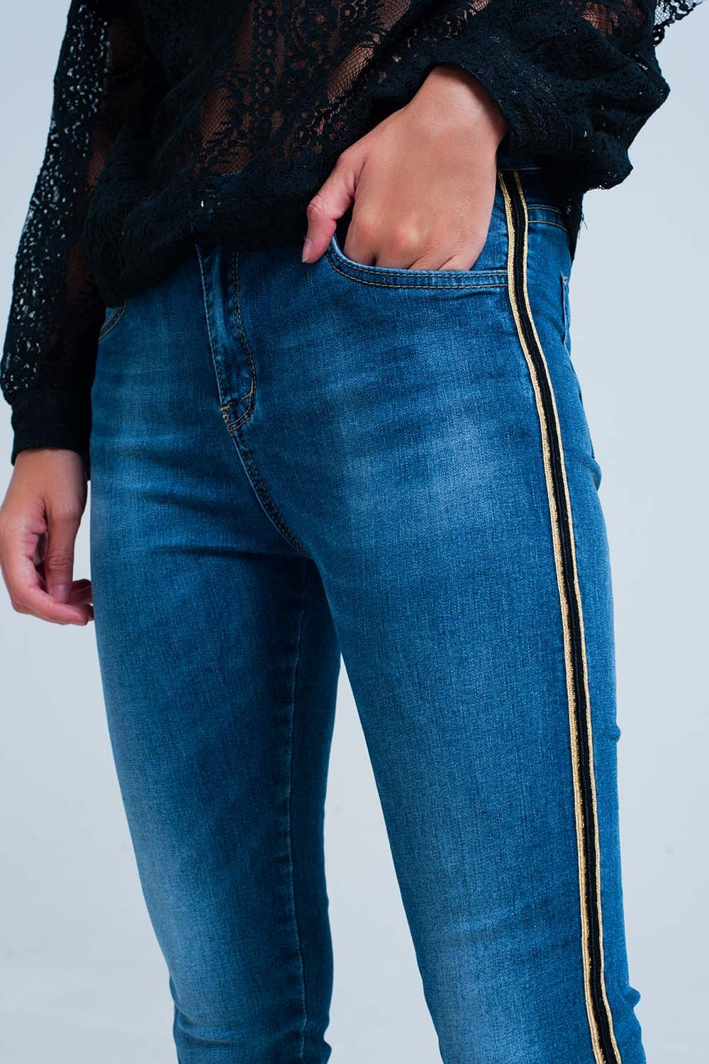 Calças de ganga azul com faixa lateral dourada e preta