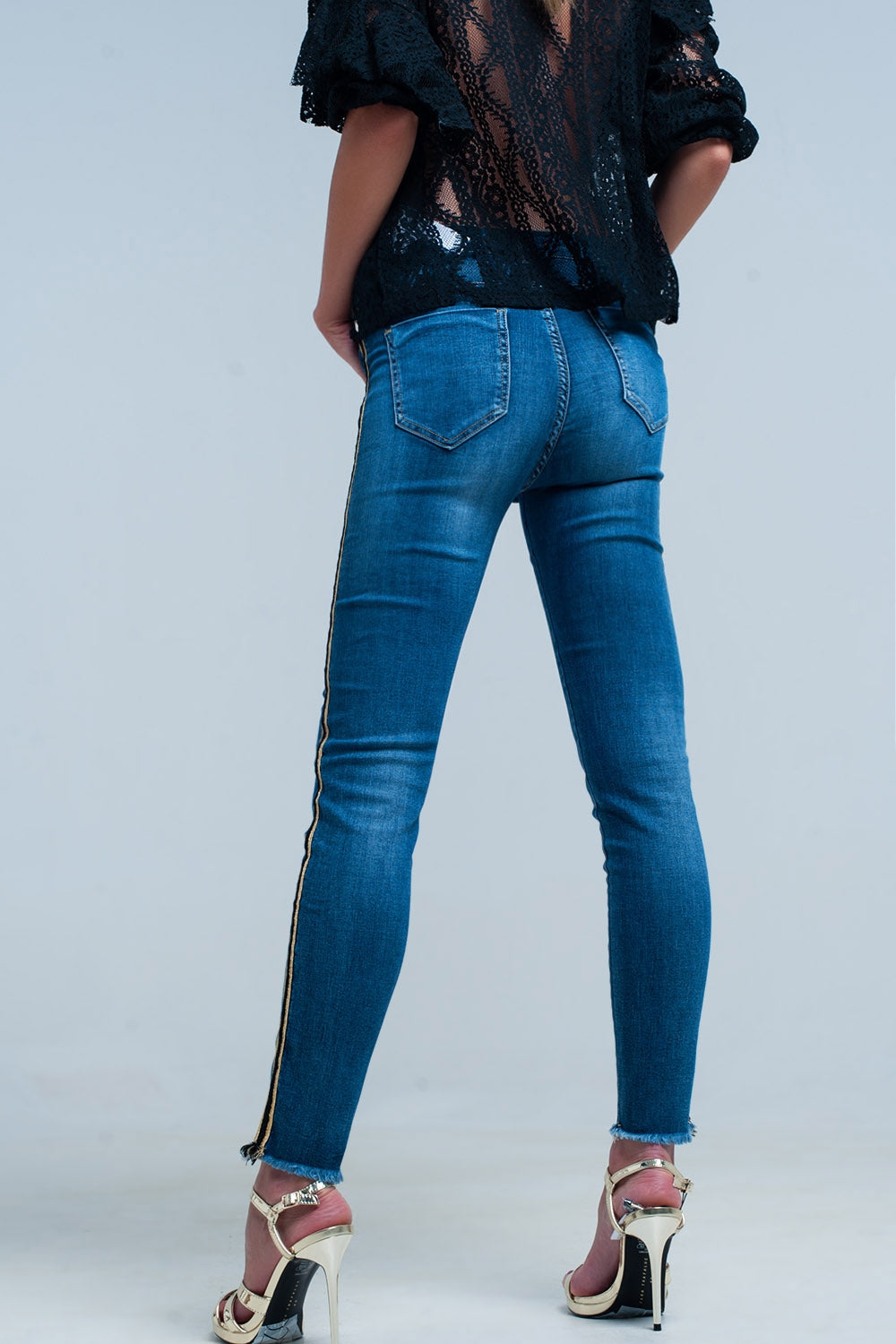 Calças de ganga azul com faixa lateral dourada e preta