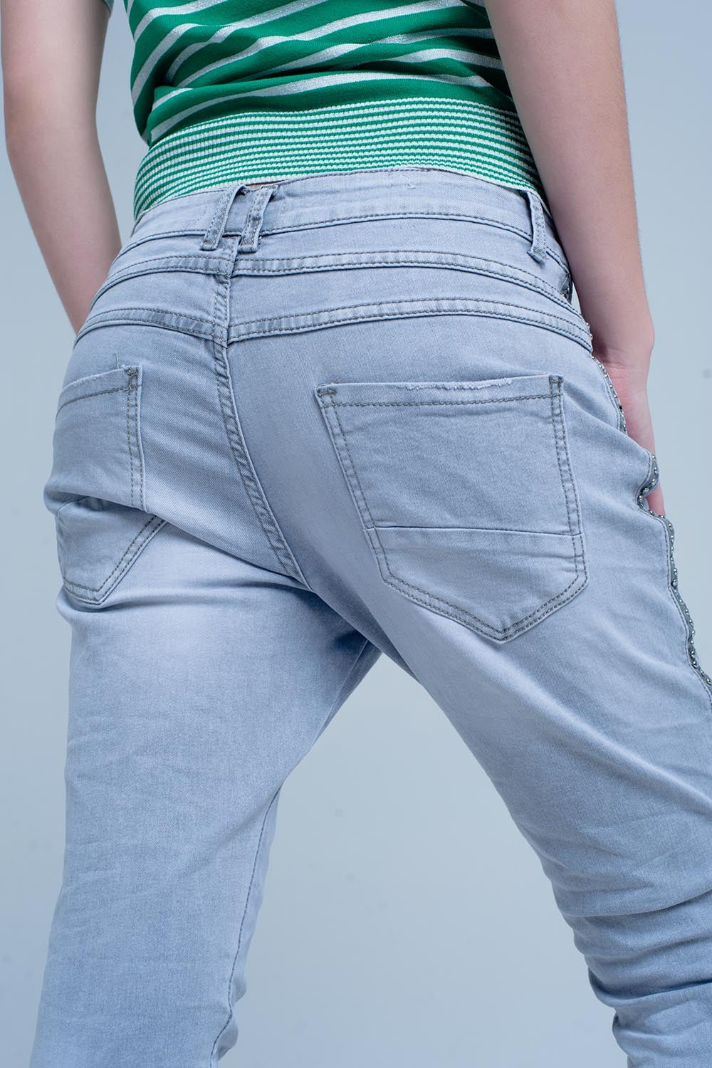 jeans cinza com detalhes de metal no lado