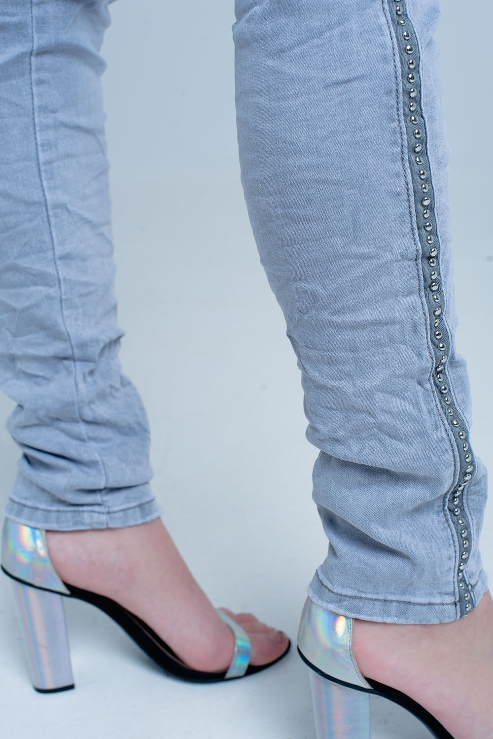 jeans cinza com detalhes de metal no lado